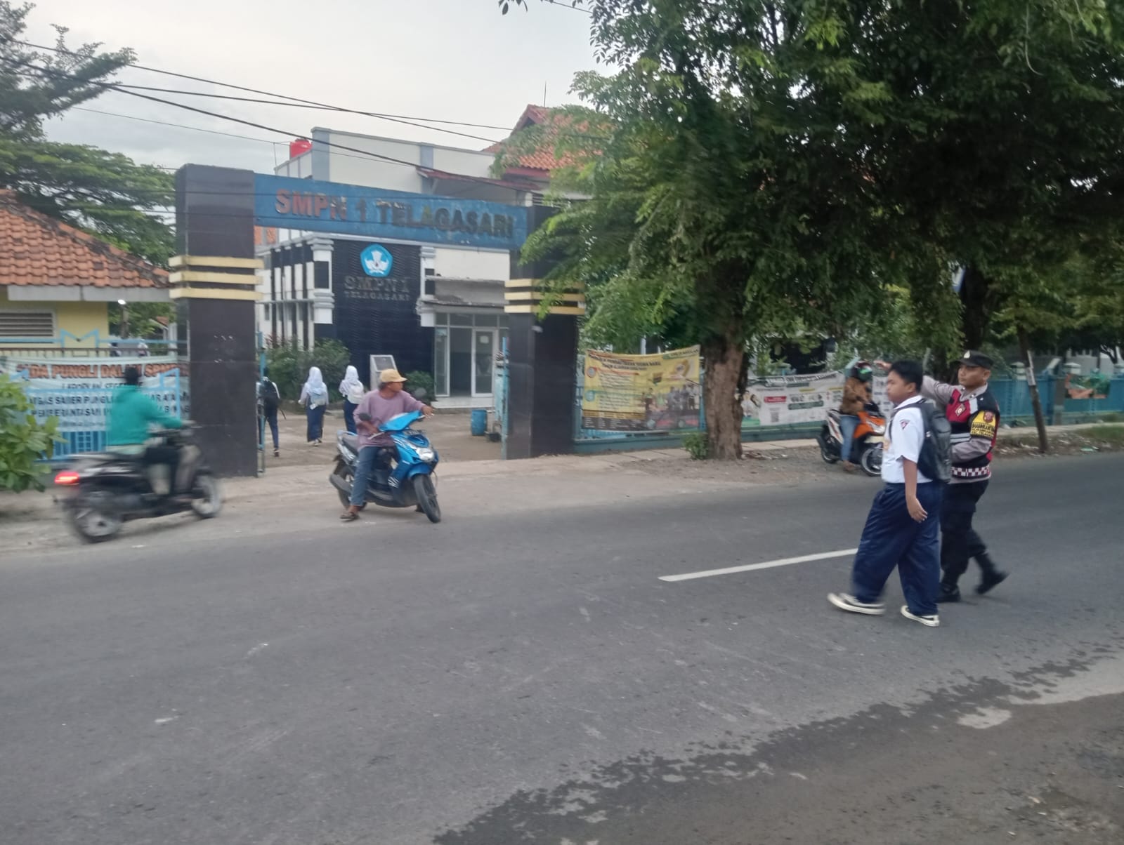 Bhabinkamtibmas Polsek Telagasari Pastikan Siswa Menyebrang dengan Aman