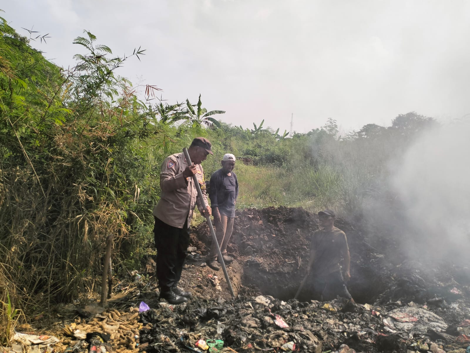 Gotong Royong Bhabinkamtibmas Polsek Klari dan Warga Desa Anggadita Bersihkan Sampah
