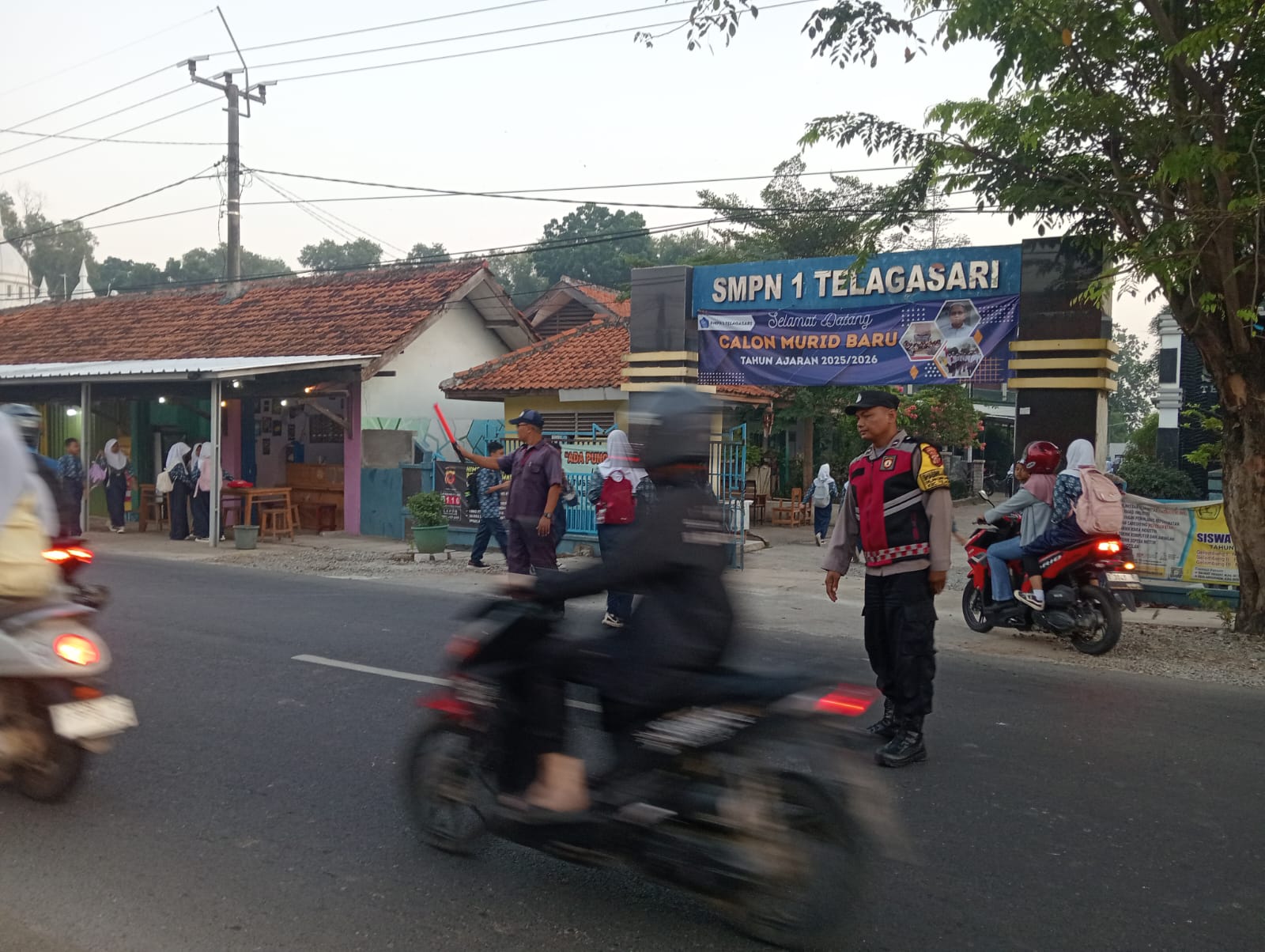 Bhabinkamtibmas Polsek Telagasari Bantu Sebrangkan Siswa Saat Gatur