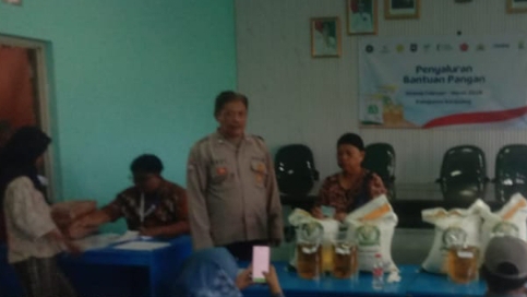 Personil Polsek Telukjambe Barat Monitoring Kegiatan Penyaluran Bantuan Pangan Warga Desa Mekarmulya
