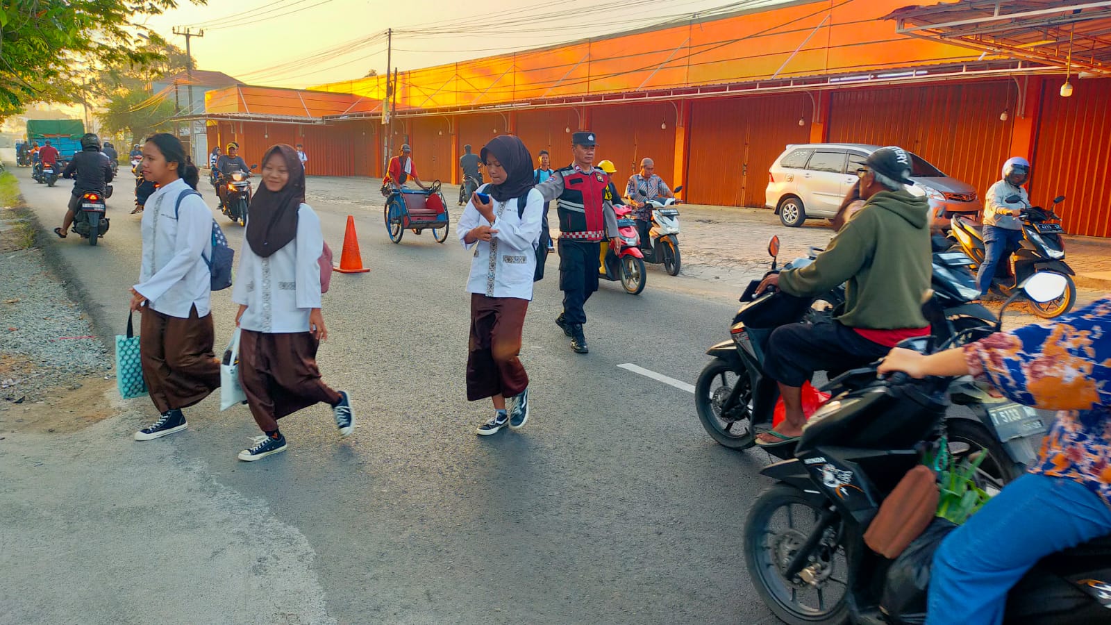 Laksanakan Pelayanan Bagi Masyarakat, Bhabinkamtibmas Polsek Telagasari Bantu Siswa Menyebrang