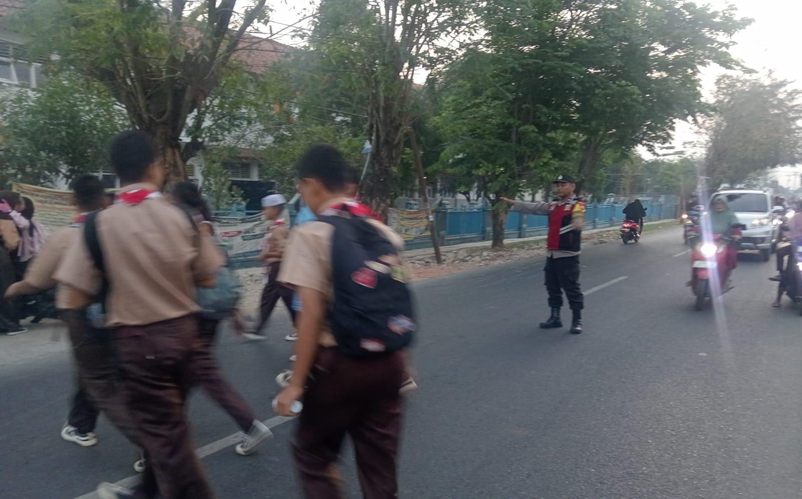 Bhabinkamtibmas Polsek Telagasari Bantu Sebrangkan Siswa Saat Gatur