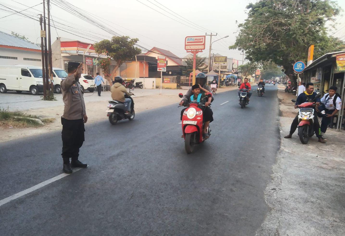 Laksanakan Pelayanan Bagi Masyarakat, Bhabinkamtibmas Polsek Telagasari Bantu Siswa Menyebrang