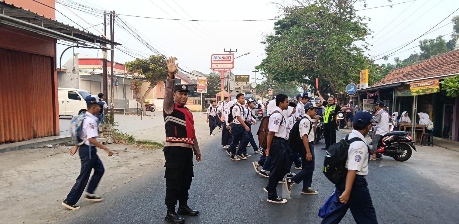 Laksanakan Gatur Pagi, Personil Polsek Telagasari Bantu Siswa Menyebrang dengan Aman