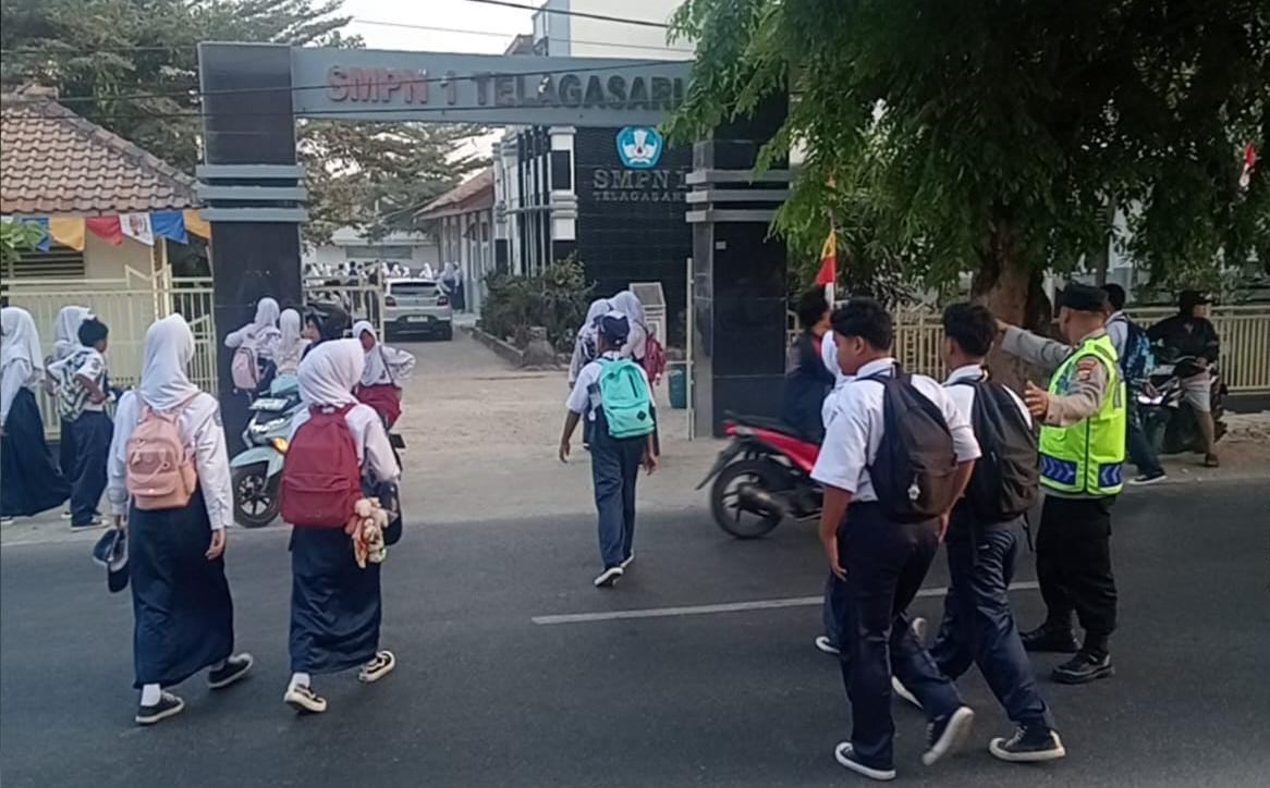 Polsek Telagasari Sapa Warga dan Bantu Siswa Menyebrang di Pagi Hari