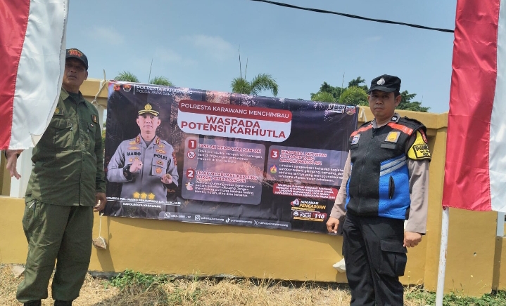 Bhabinkamtibmas Polsek Klari Pasang Spanduk Imbauan Karhutla di Pagar Kantor Desa Walahar