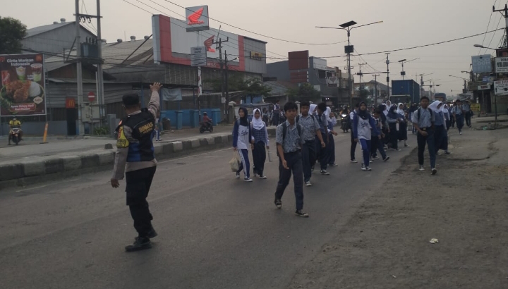 Personel Polsek Klari Sapa Pagi, Gatur Lalin dan Bantu Seberangkan Anak Sekolah