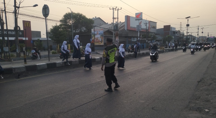 Polsek Klari Polresta Karawang Sapa Warga dan Bantu Pelajar Menyebrang di Pagi Hari