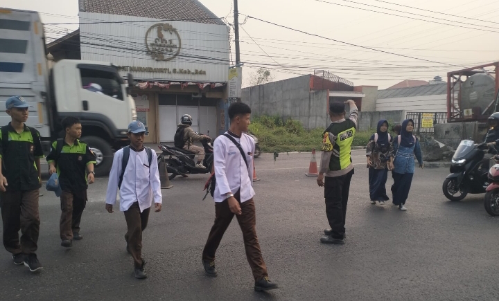 ‎Personel Polsek Klari Sapa Pagi, Bantu Masyarakat dan Pelajar Menyeberang Jalan di Depan Kantor Kecamatan Klari