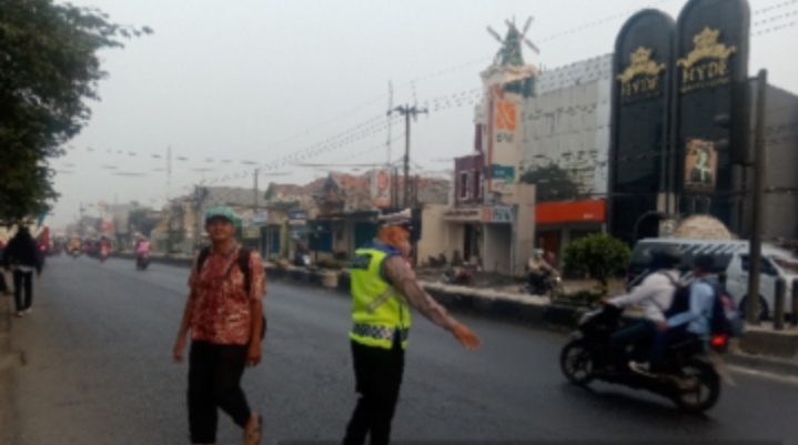 Sapa Pagi, Personel Polsek Klari Hadir di Tengah Masyarakat, Bantu Seberangkan Pengguna Jalan